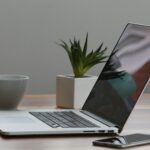 Free Minimalist home office desk with laptop, smartphone, and plant for a modern work environment. Stock Photo
