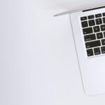 Free Aerial view of a sleek laptop keyboard on a clean, white surface, ideal for tech backgrounds. Stock Photo