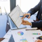 Free Business professionals discussing financial graphs and charts in an office setting. Stock Photo